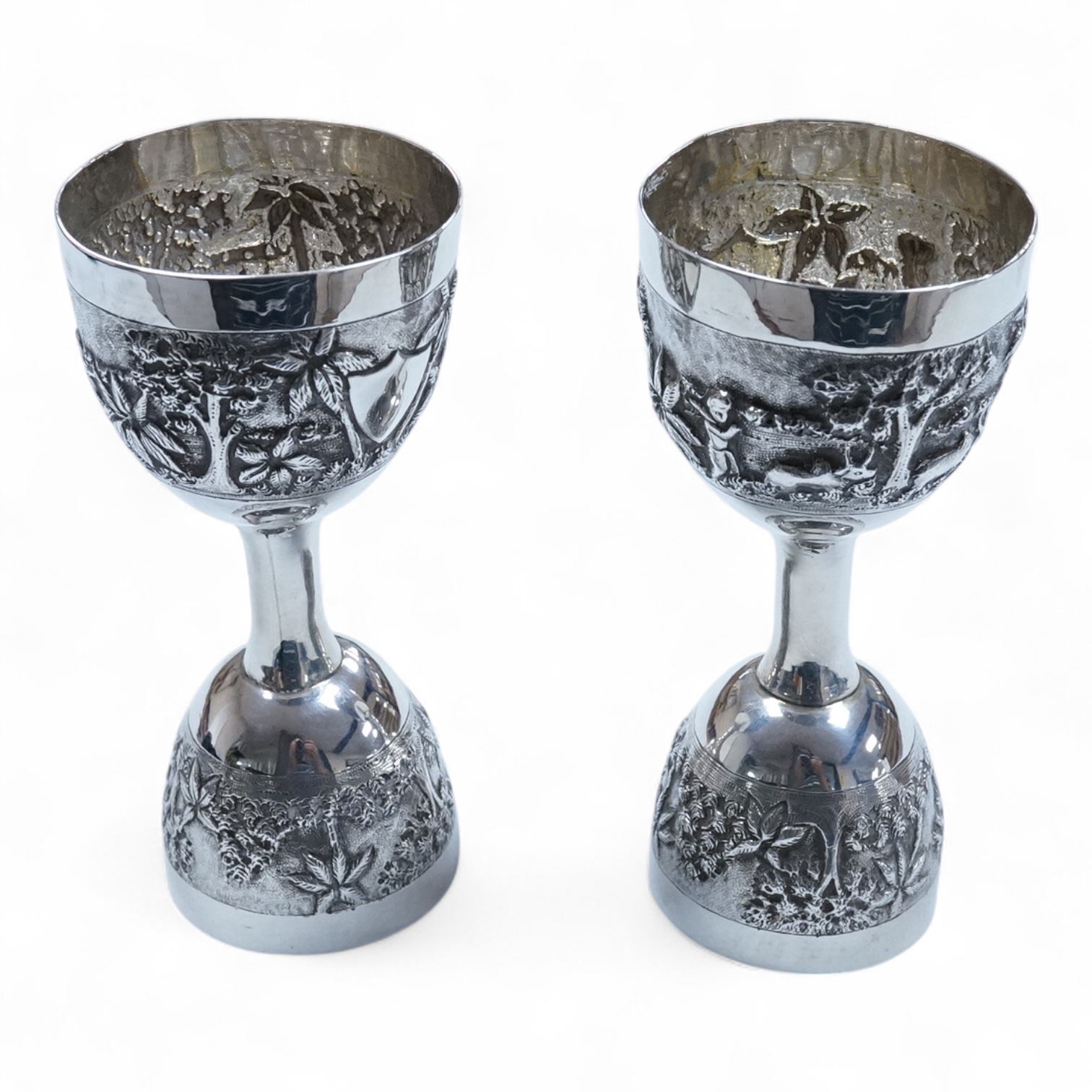 A pair of Indian embossed white metal single and double ended measures, 11.9cm, 5.2oz.